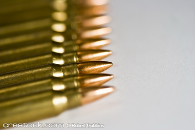 Combate Row of rifle rounds on white sharp focus going...